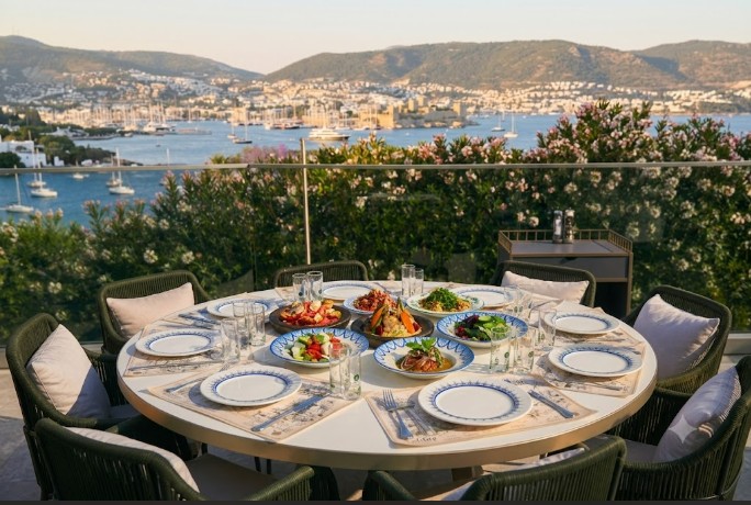 Afitap Meyhane Bodrum with stunning Bodrum Castle view, elegant terrace dining, Turkish mezes, sunset atmosphere, and luxury seaside restaurant experience.